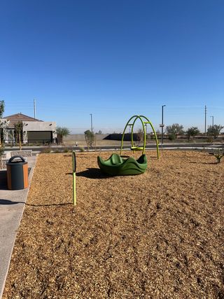 A modern playground with unique green structures in Miravida by Mattamy Homes (Surprise, AZ).