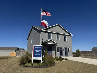Street view A modern gray two-story home with manicured landscaping in Cielo Gardens: Welton Collection by Lennar (Jarrell, TX).