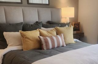 Model Home A warm and inviting primary bedroom with plush bedding, soft lighting, and a stylish neutral palette.