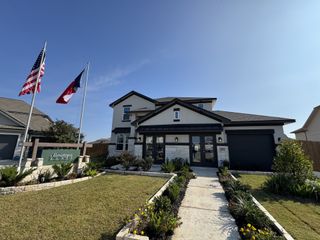 Street view A beautiful modern home with manicured landscaping in Morningstar by Saratoga Homes (Georgetown, TX).