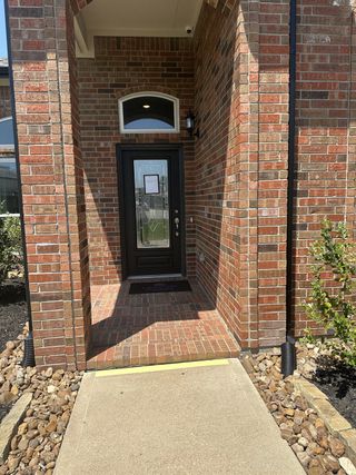 Elegant brick entrance with modern glass door in Walden on Lake Conroe by Legend Homes (Montgomery, TX).