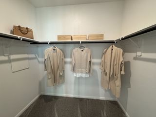 Well-organized walk-in closet offers ample storage with built-in shelving and rods, perfect for keeping your wardrobe tidy and accessible.