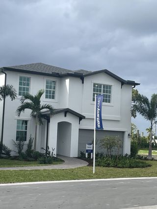 Stylish white modern home with tropical landscaping in Forest – Townhomes by Mattamy Homes (Lake Worth, FL).