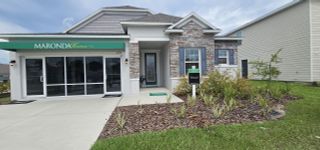 A charming stone-accented home with lush landscaping in Avalon Woods by Maronda Homes (Newberry, FL).