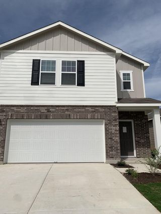 A modern brick and siding home with a spacious garage in Sonterra by Starlight Homes, Jarrell, TX.
