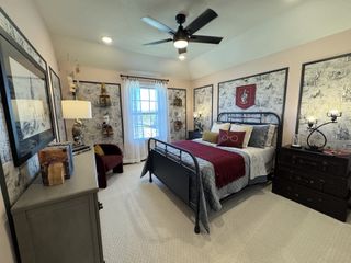 A cozy bedroom featuring a themed decor, framed art, a black metal bed, and elegant lighting. Perfect blend of comfort and style.