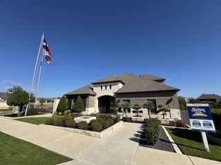 Street view A beautiful stone-accented home with manicured landscaping in Anthem by Brightland Homes (Kyle, TX).