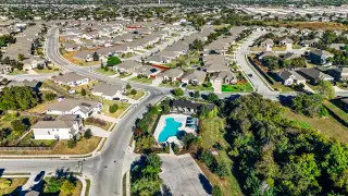 Aerial view of Cypress Forest community by Scott Felder Homes in Kyle, TX, featuring scenic streets and a community pool.