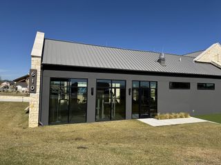 A modern building with sleek metal roofing and stone accents in Nolina 60' by Perry Homes (Georgetown, TX).
