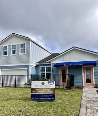 Street view Charming blue model home with white trim in Cherry Elm at SilverLeaf by Dream Finders Homes, St. Augustine, FL.