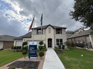 A grand entrance featuring a charming arched doorway and elegant shutters in Crescent Bluff by Pulte Homes (Georgetown, TX).