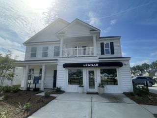 A modern white two-story home with a porch and balcony in Cypress Preserve: Arbor Collection by Lennar (Moncks Corner, SC).