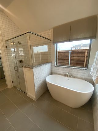 Model Home A modern bathroom with striking tile, a sleek vanity, and bright lighting.