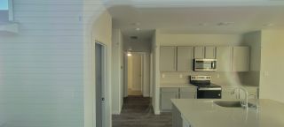 A modern kitchen with sleek gray cabinetry, stainless steel appliances, and a spacious island with a sink.