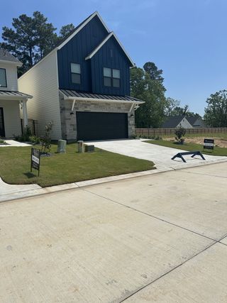 A modern dark blue and white home with landscaped yard in Summer Place 35' by Tricoast Homes (Montgomery, TX).