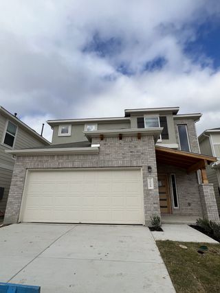 Street view Modern brick home with a spacious garage in Messinger Village by Milestone Community Builders (Austin, TX).