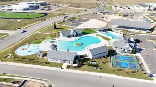 Aerial view of vibrant amenities including a pool, sports courts, and community hub at Santa Rita Ranch by Scott Felder Homes (Liberty Hill, TX).