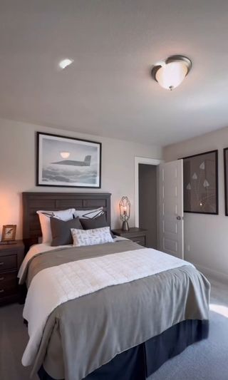 A cozy bedroom featuring neutral tones, modern decor, and a sleek bedside lamp for a serene atmosphere.