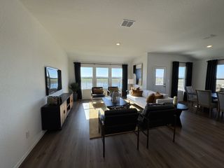 A spacious living room with sleek hardwood floors, large windows, and modern furnishings creating a bright, inviting atmosphere.