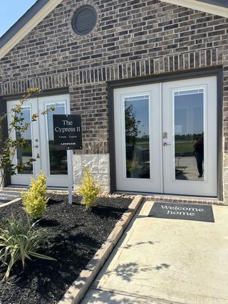 A charming brick home facade with stylish landscaping at Crosby Farms by Lennar in Crosby, TX.