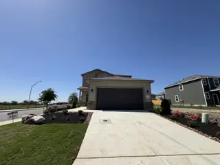 A modern home with a manicured lawn and spacious driveway in Blue Ridge Ranch by View Homes (San Antonio, TX).