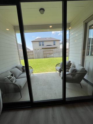 Model Home A cozy patio with modern seating overlooks a green backyard, perfect for relaxation and gatherings.