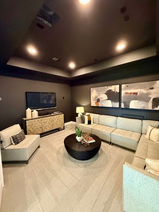A cozy media room with plush sectional seating, modern artwork, and ambient lighting for a relaxing entertainment experience.