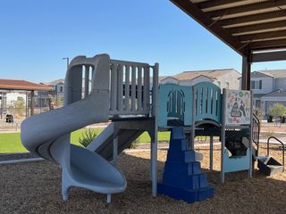 Community Amenities A vibrant playground under a covered area in Maple at North Copper Canyon by Courtland Communities (Surprise, AZ).
