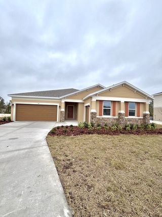 Street view Charming beige home with stone accents and a manicured yard in Brookshire by Stanley Martin Homes (Titusville, FL).