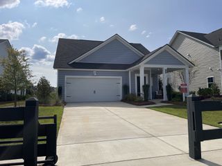Street view A charming gray home with inviting porch and manicured lawn in Sweetgrass at Summers Corner: Coastal Collection by Lennar (Summerville, SC).