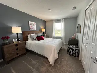 A cozy bedroom with stylish gray walls, warm lighting, and modern decor creating a welcoming and relaxing atmosphere.