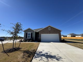 A charming brick home with a spacious driveway and lovely yard in Sonterra by Starlight Homes (Jarrell, TX).