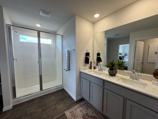 A spacious primary bath featuring a large walk-in shower, double sinks, and stylish décor.