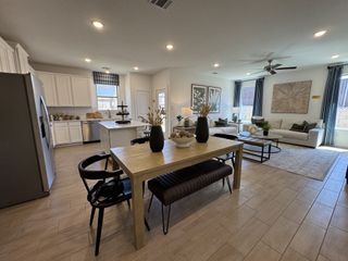 An open-concept space with a modern kitchen, light wood dining table, and stylish living area with ample natural light.