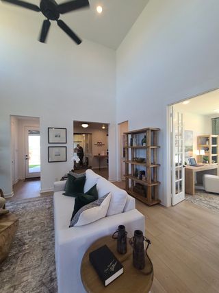 A cozy living room with a high ceiling, modern decor, and elegant built-in shelves, creating a spacious, inviting atmosphere.