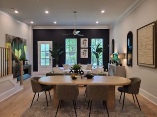 A modern dining and living area with plush seating, abstract art, and abundant natural light.