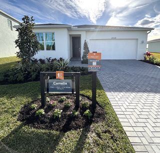Modern white home with manicured landscaping in Riverwood at Everlands: The Shoals Collection by Lennar (Palm Bay, FL).