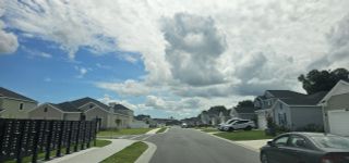 Charming neighborhood street with modern homes and manicured lawns at Millwood Estates - The Meadows by Lennar (Ocala, FL).