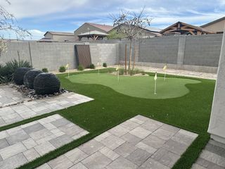 Street view A modern backyard with a putting green, stone accents, and sleek landscaping in Pinnacle at San Tan Heights by Mattamy Homes (San Tan Valley, AZ).