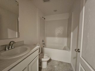 A modern bathroom featuring a sleek vanity, tiled bathtub, and contemporary fixtures.