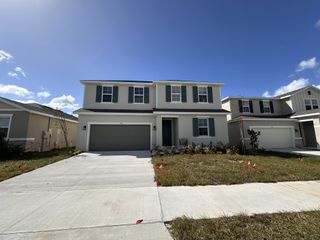A modern two-story home with green shutters and a manicured lawn in Seasons at The Grove by Richmond American Homes (Mascotte, FL).