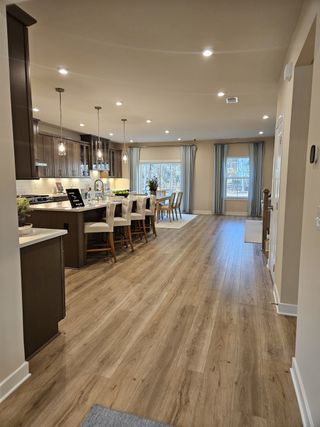 An elegant kitchen with wood flooring, pendant lighting, and spacious dining area, creating a warm, inviting atmosphere.
