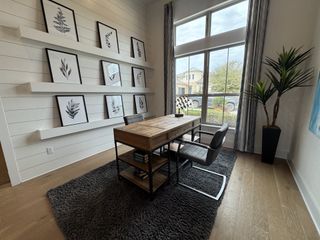 A modern home office with shiplap walls, floating shelves, and abundant natural light for a productive workspace.