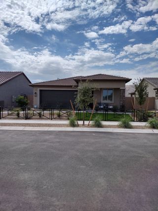 A charming modern home with a manicured yard in The Residences Collection at Frontera by New Home Co. (Surprise, AZ).