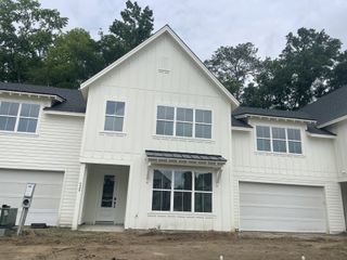 A charming white-paneled home with large windows in Hayes Park by New Leaf Builders (Johns Island, SC).