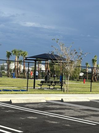 Community Amenities A community park with lush greenery and picnic spots in Valencia Walk at Riverland by GL Homes (Port St. Lucie, FL).