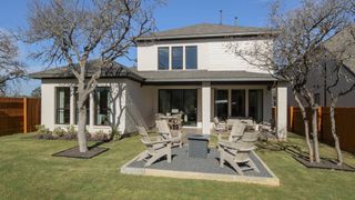 A modern home with a spacious backyard and patio in Parkside Peninsula 50' by Perry Homes (Georgetown, TX).