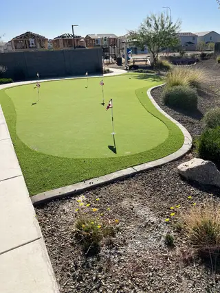 Community Amenities A serene putting green surrounded by a landscaped area in The Ridge Collection at Superstition Vista by Century Communities (Apache Junction, AZ).