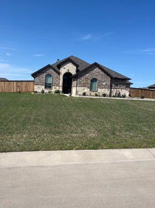 A charming stone and brick home with a spacious yard in High Meadows Estates by Robbie Hale Homes (Nevada, TX).