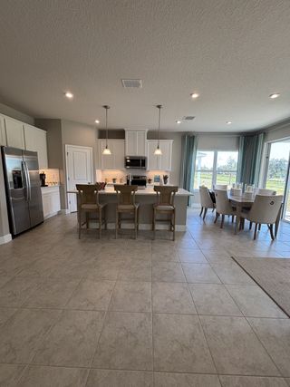 A modern, open-concept home with a spacious and elegant design. The home features a seamless flow between the kitchen, dining, and living areas, creating a bright and airy atmosphere. 